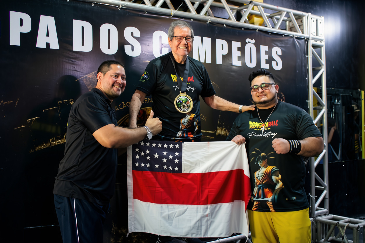 Atleta master medalhista com a bandeira do Amazonas ao lado da organização